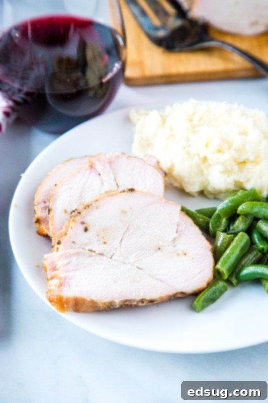 Artisan Smoked Turkey Breast 3 Plate of tender smoked turkey slices with creamy mashed potatoes and vibrant green beans.