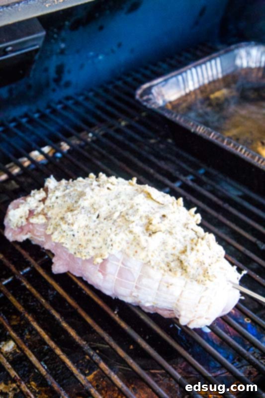 Artisan Smoked Turkey Breast 5 Turkey breast cooking low and slow on a smoker, surrounded by smoke.