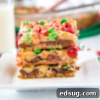 Christmas magic bars stacked on a white plate, showing the festive colors and delicious layers