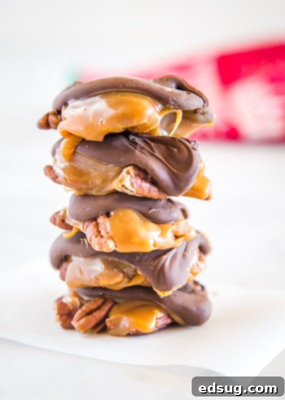 Homemade Turtle Candy stacked on top of each other, showcasing the distinct layers of chocolate, caramel, and pecans.