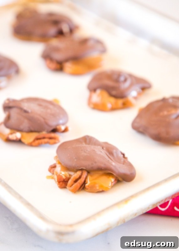 A baking tray filled with freshly made homemade Turtle Candy, glistening with chocolate and caramel.