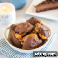 Close up view of a bowl filled with homemade Turtle Candy, glistening with chocolate.