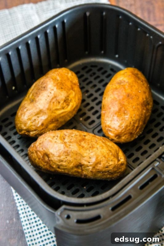 Crispy Air Fryer Baked Potato 4 cooked baked potatoes in the air fryer basket