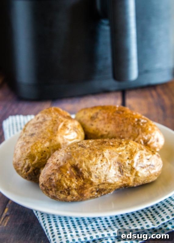 Crispy Air Fryer Baked Potato 5 cooked baked potatoes on a white plate