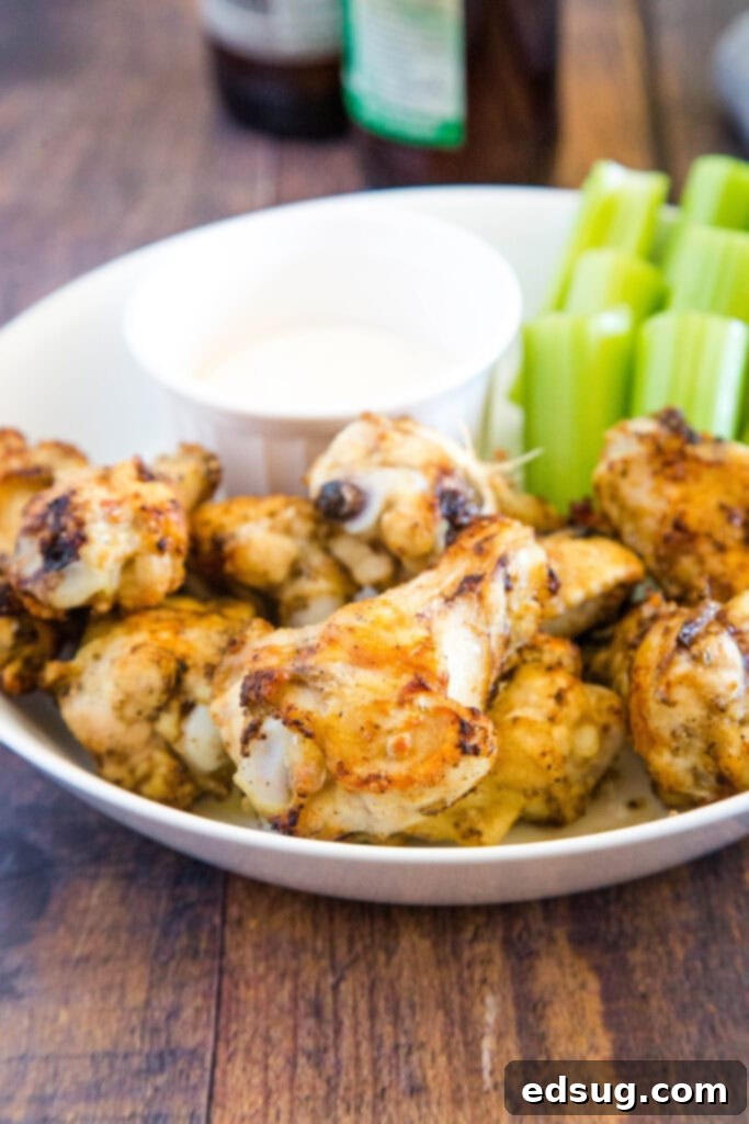 Crispy Air Fryer Chicken Wings 3 cooked chicken wings on plate with celery sticks