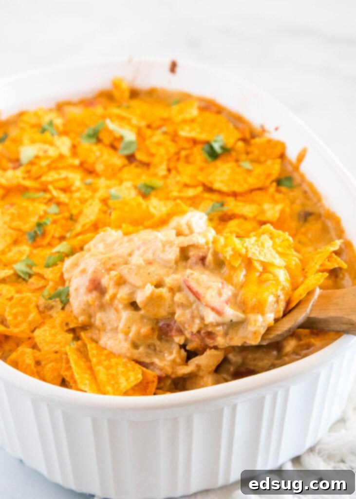 Crunchy Dorito Chicken Bake 2 spooning chicken casserole out of the dish