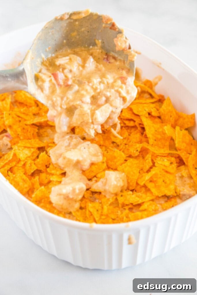 Crunchy Dorito Chicken Bake 3 layering the chicken and sauce in a chicken casserole