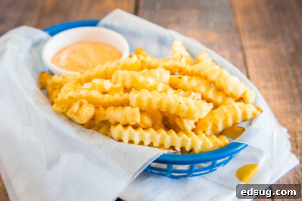 A close-up view of perfectly air-fried French fries, golden and crispy, in an air fryer basket.