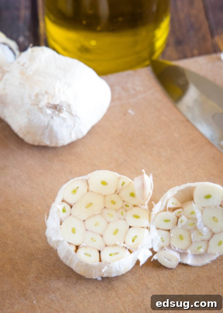 raw head of garlic on cutting baord