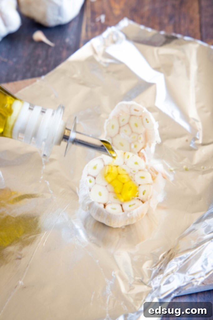 pouring olive oil on head of garlic