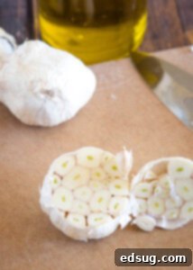 raw head of garlic on cutting baord