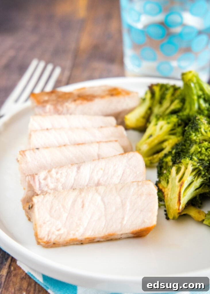 Effortlessly Perfect Sous Vide Pork Chops 7 Perfectly cooked and sliced sous vide pork chop served on a plate with fresh broccoli florets.