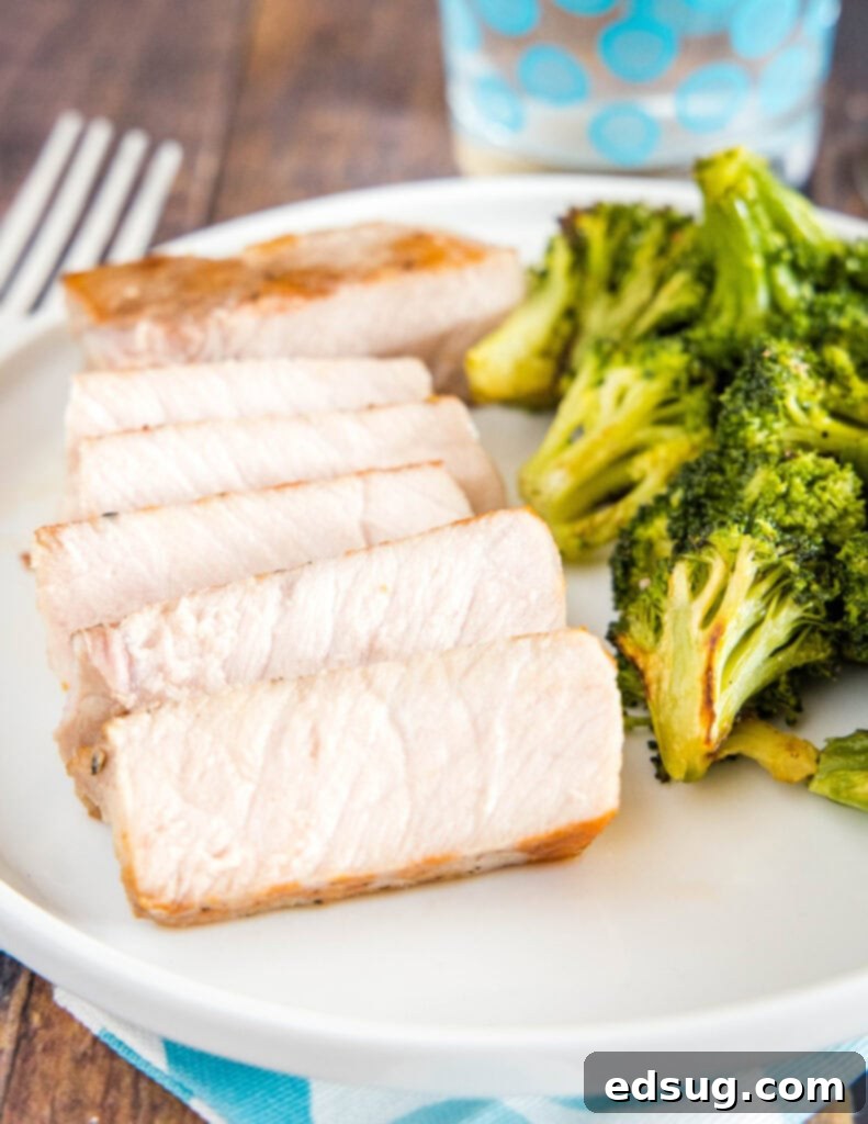 Effortlessly Perfect Sous Vide Pork Chops 9 Sliced sous vide pork chop on a plate with roasted broccoli, highlighting its succulent texture.