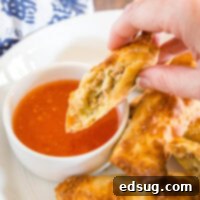 Perfect Air Fryer Egg Rolls 12 close up of cut egg roll being dipped in sauce