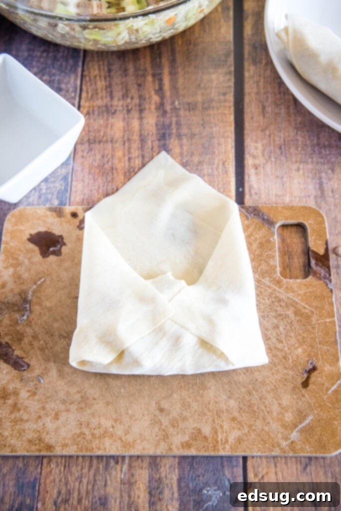 Perfect Air Fryer Egg Rolls 7 fold the sides over the filling of an egg roll