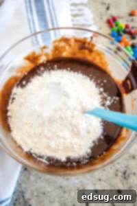 Colorful M and M Brownies 9 mixing flour into brownie batter