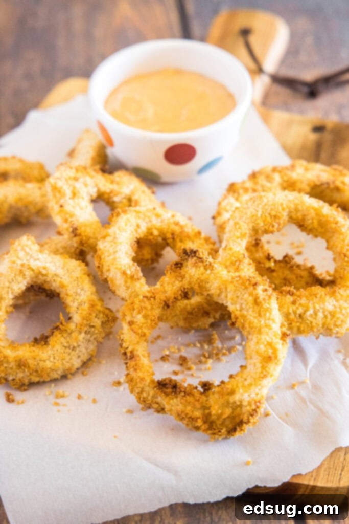 Crispy Air Fryer Onion Rings 2 Crispy air fryer onion rings served on a cutting board, ready to be enjoyed.