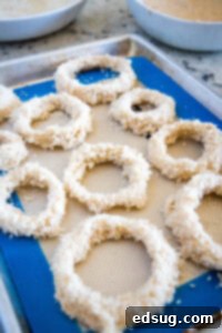 Crispy Air Fryer Onion Rings 11 Coated onion rings on a baking sheet