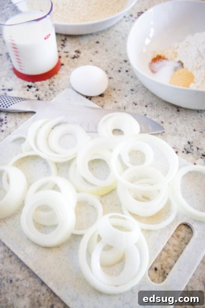Crispy Air Fryer Onion Rings 3 Various ingredients for making air fryer onion rings laid out on a kitchen counter.