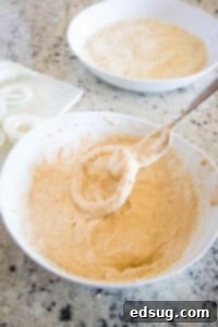 Crispy Air Fryer Onion Rings 9 Onion ring being coated in buttermilk batter