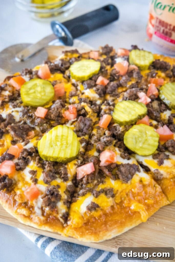 Loaded Burger Pie 5 A perfectly baked Cheeseburger Pizza sliced on a cutting board, ready for serving.
