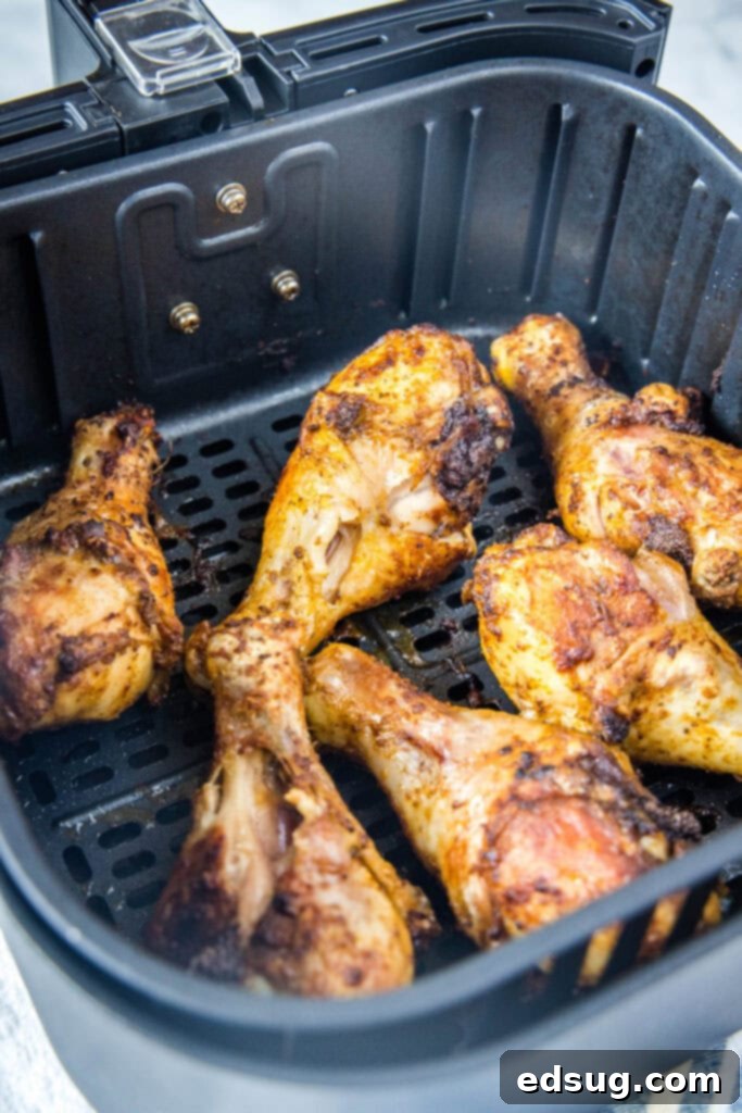 Crispy Air-Fried Chicken Drumsticks 5 Cooked chicken drumsticks in an air fryer basket