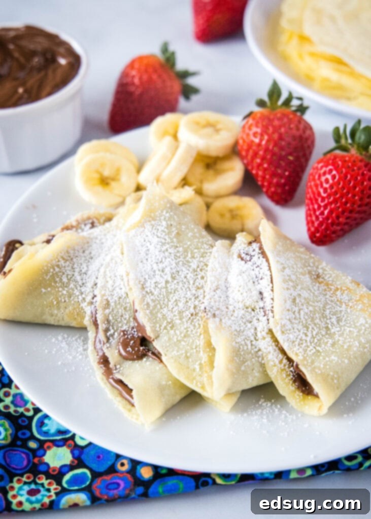 nutella crepes on a plate, garnished with powdered sugar
