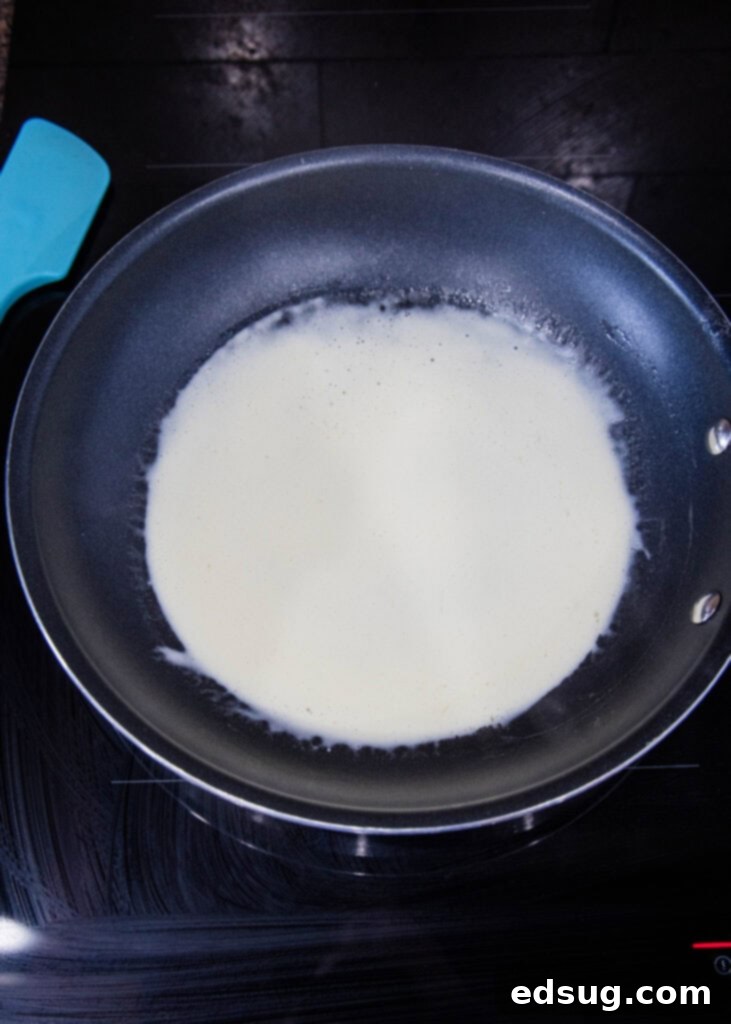 crepe batter being poured into a hot pan