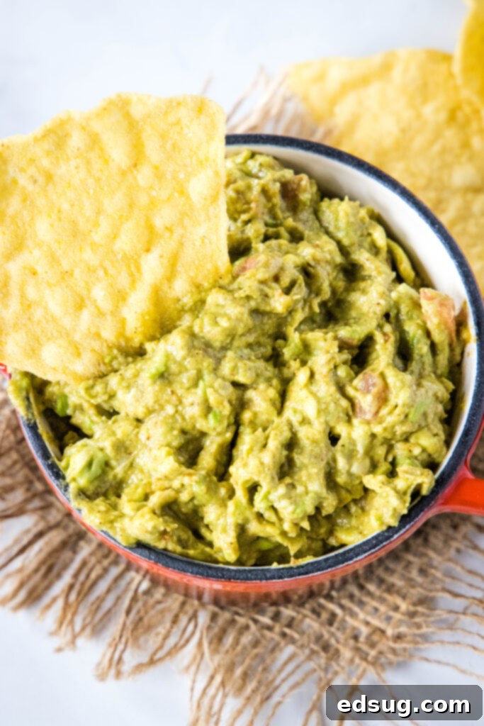 looking down on a bowl of guacamole with ingredients mixed in