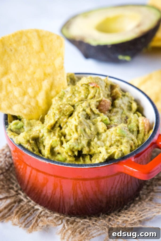 a chip dipping into a bowl of guacamoel