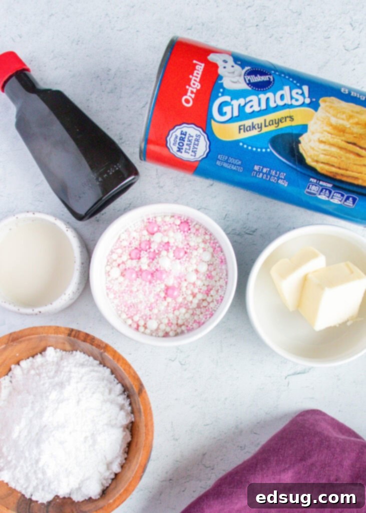 A flat lay shot of ingredients needed to make donuts in the air fryer, including biscuit dough, butter, powdered sugar, vanilla, milk, and sprinkles.