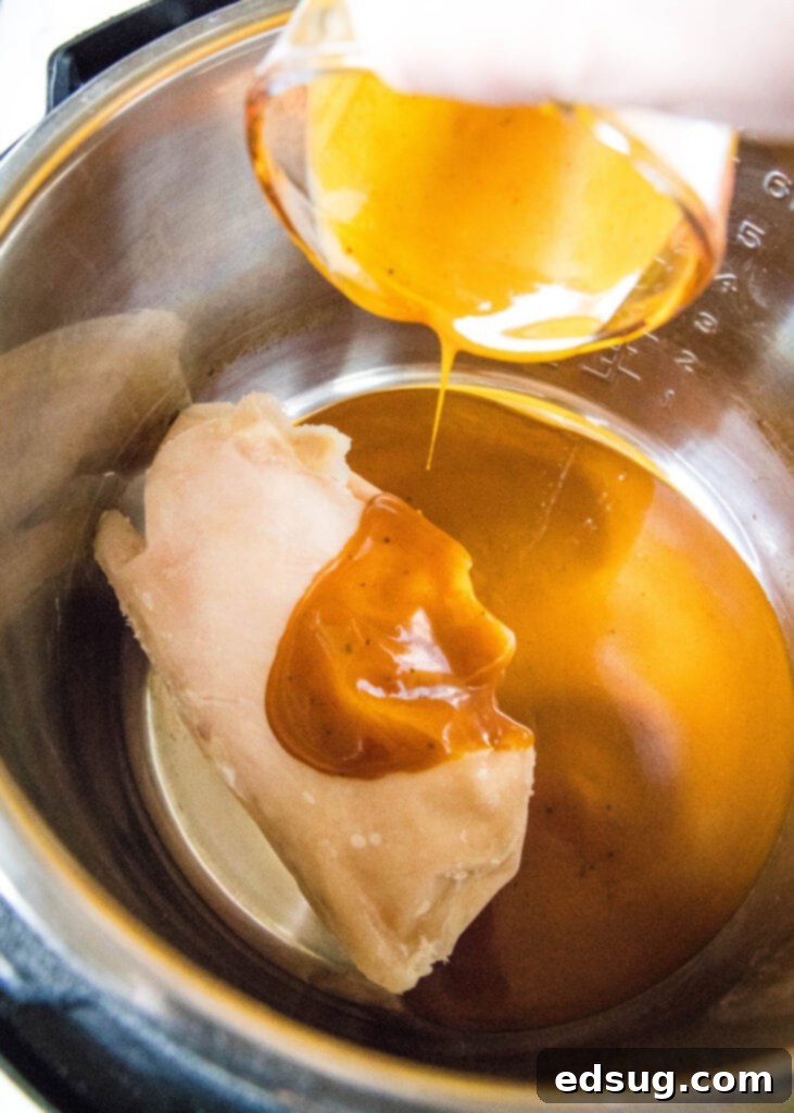 Effortless Instant Pot BBQ Chicken 4 Pouring homemade BBQ sauce over chicken in the Instant Pot