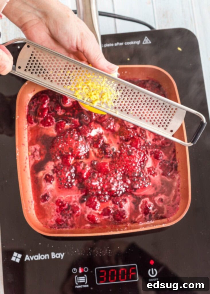 Effortless Raspberry Sauce 4 Adding fresh lemon zest to the simmering raspberry sauce for a bright, aromatic finish.