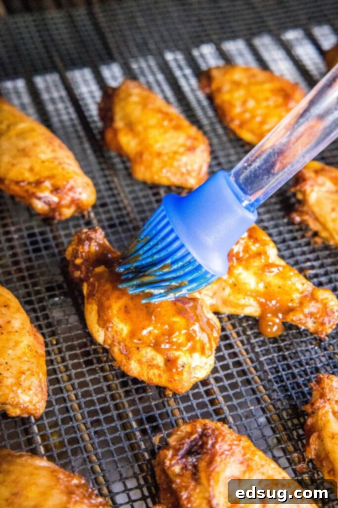 brushing barbecue sauce on chicken wings