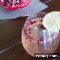 Crimson Fizz 2 A refreshing glass of Pomegranate Prosecco, garnished with lime and pomegranate seeds.