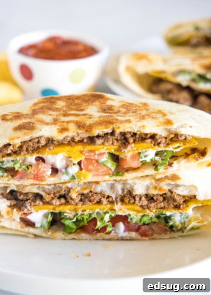 Ultimate Crispy Wrap 2 Crunchwrap Supreme on a plate, cut in half to show layers