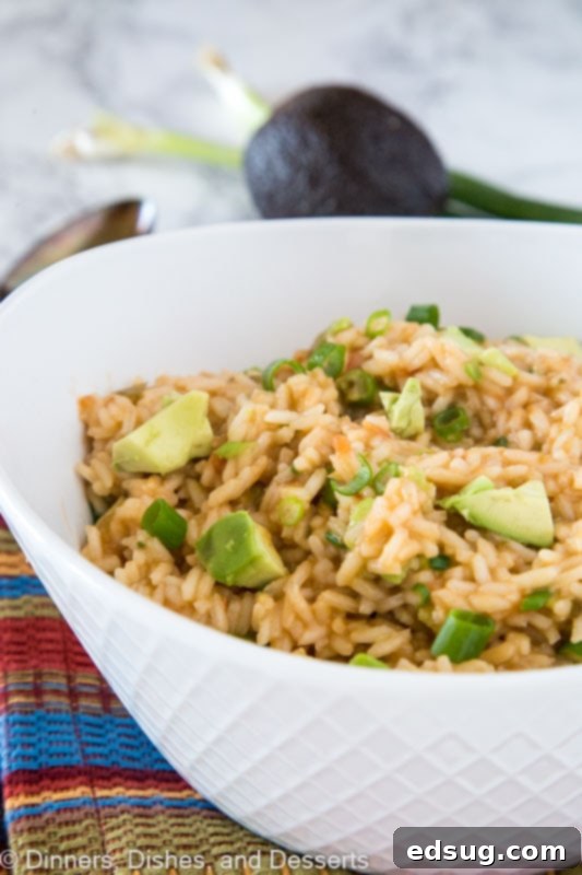 Close-up of a bowl of creamy Mexican rice with avocado, highlighting the textures and colors.