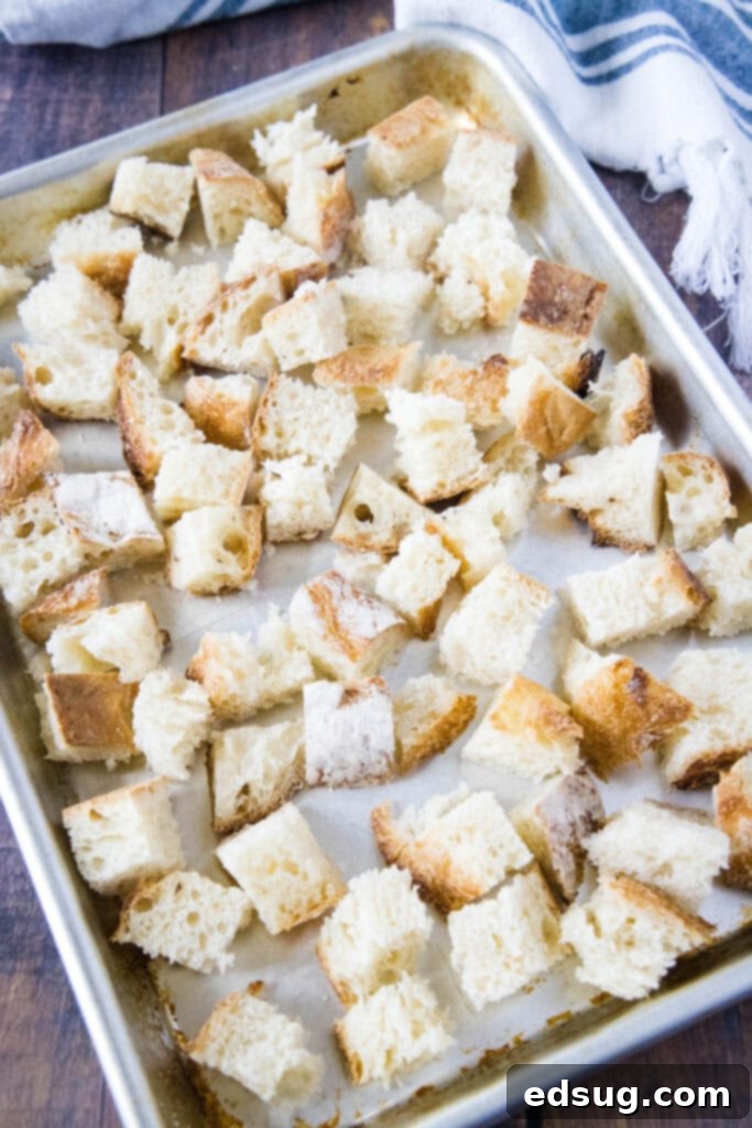 Crispy Homemade Croutons 3 Looking down at neatly diced bread cubes on a baking tray, ready for seasoning