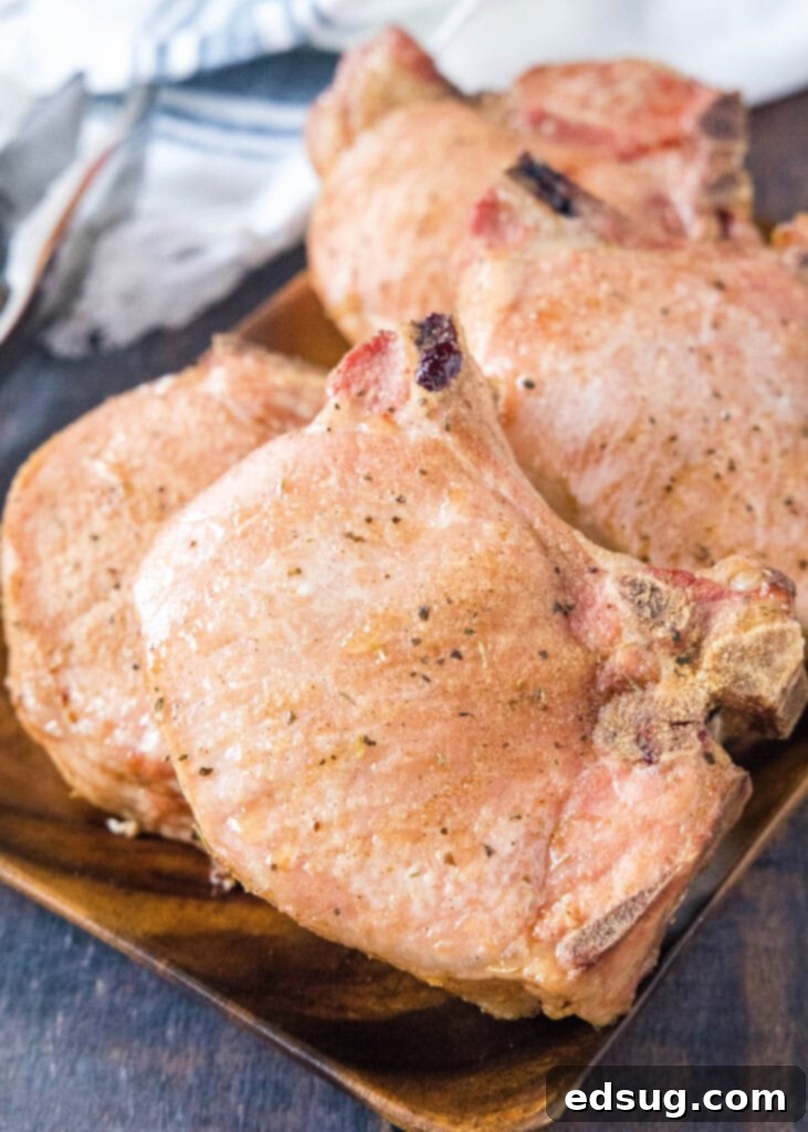 Succulent Smoked Pork Chops 2 Smoked pork chops resting on a rustic wooden tray, ready to be served.