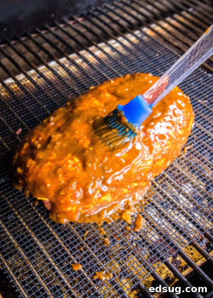 brushing barbecue sauce on meatloaf