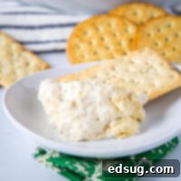 A top-down shot of the hot artichoke dip, freshly baked and golden brown, in a round dish.
