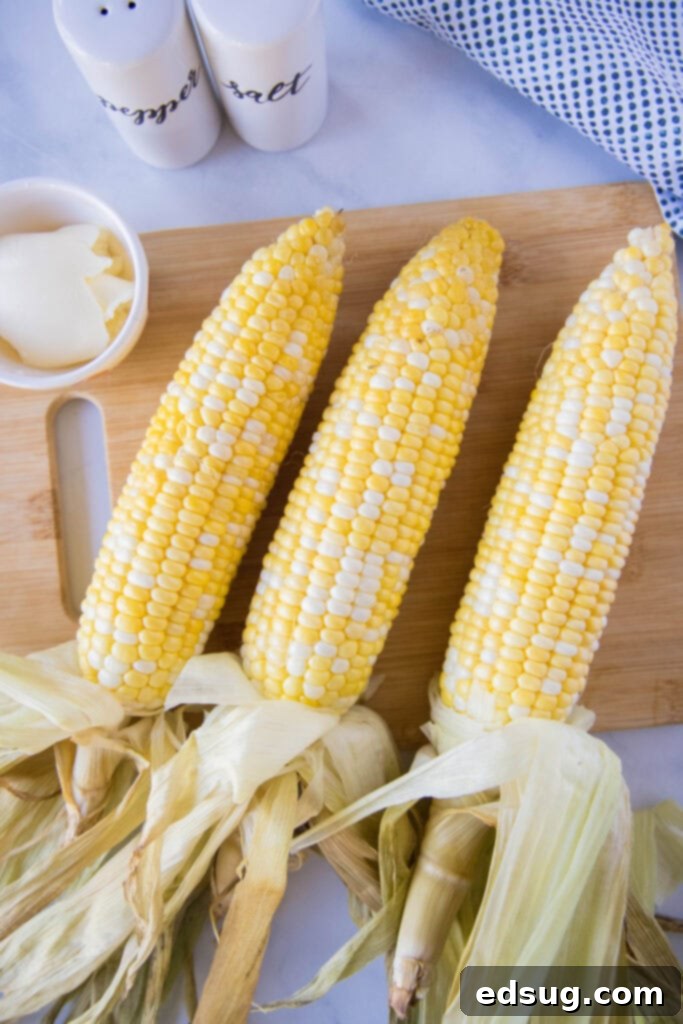 Smoked corn on the cob resting on a cutting board, ready to be served.