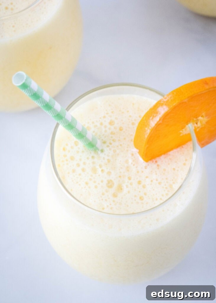 Homemade Orange Julius Perfection 6 looking down on a frothy orange drink in a glass