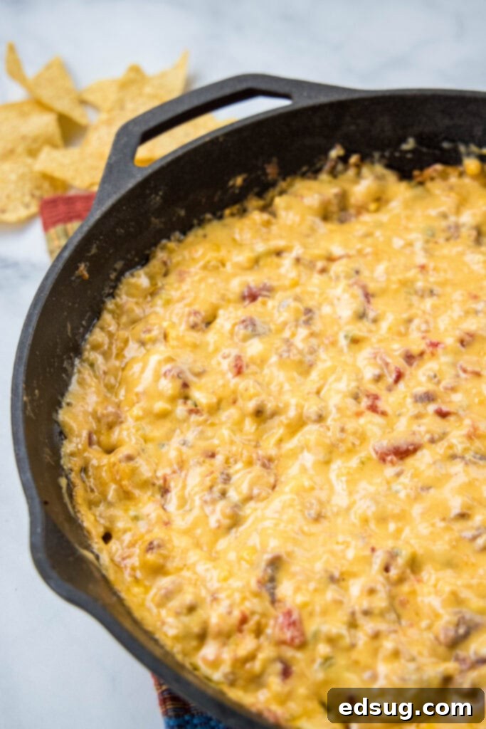 Creamy Smoked Queso Dip 5 Close-up of creamy, hot smoked queso in a cast iron skillet, ready for serving.
