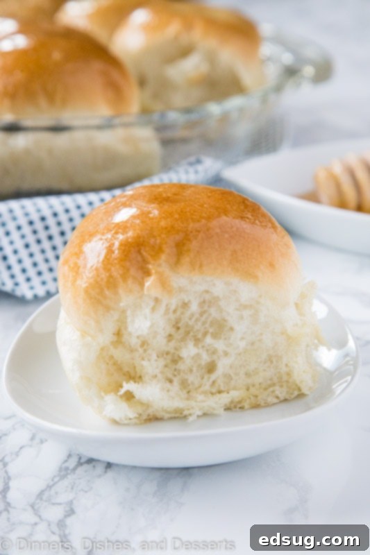 Golden Honey Butter Dinner Rolls 2 A perfectly golden-brown dinner roll on a plate, ready to be enjoyed.
