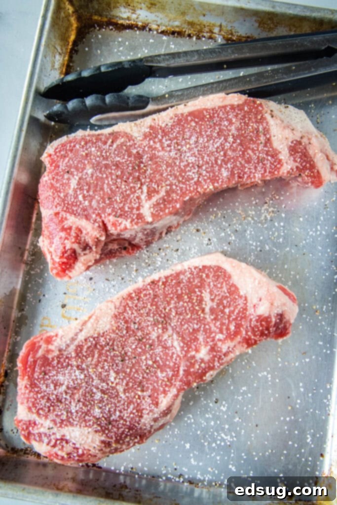 seasoned steak on baking tray