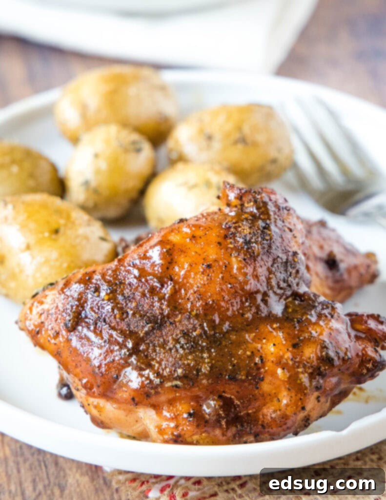 a chicken thigh on a plate with potatoes