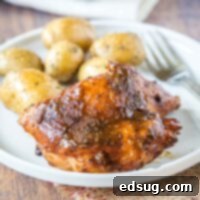 cropped image of a chicken thigh with barbecue sauce on a plate