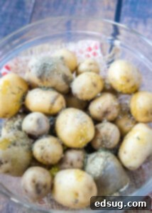 seasoning potatoes in a glass bowl