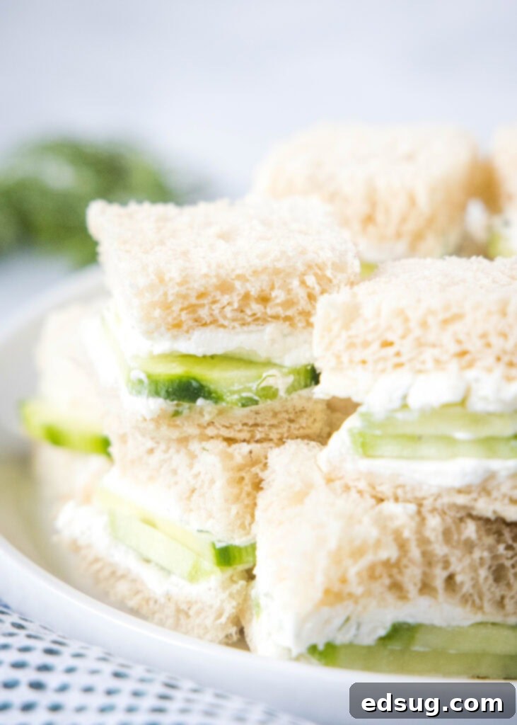Cucumber Sandwiches 2 A stack of perfectly prepared cucumber tea sandwiches on a white plate, ready to be served at high tea.